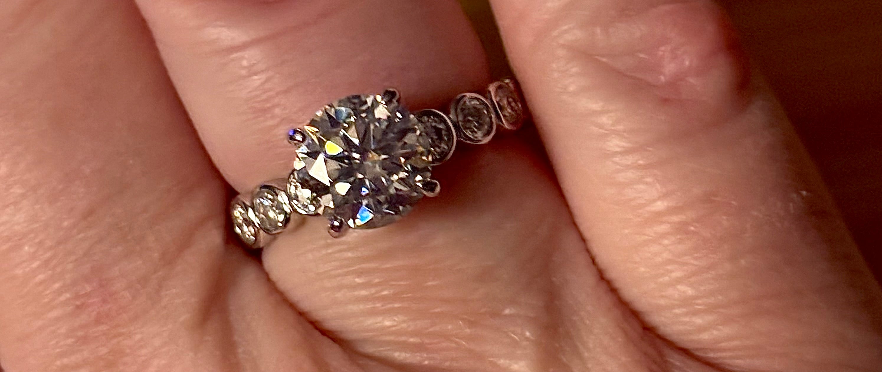 A 3.8cttw designer Moissanite ring with a certified 3ct center stone and 10-point bezel-set stones in sterling silver and 18k gold!