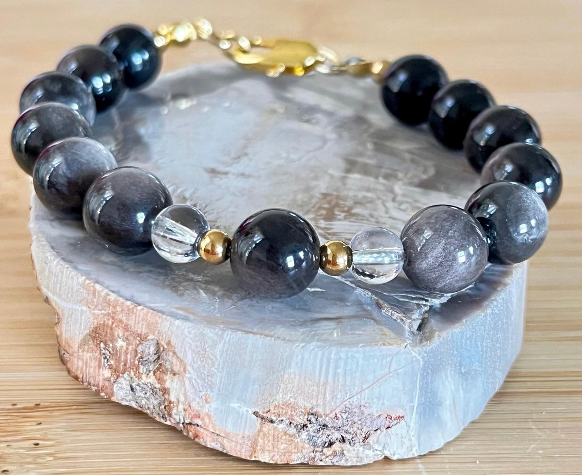 Silver sheen obsidian and clear quartz bracelet and earrings. Pair the “Silver Bells” bracelet and/or earrings with your little black party dress and be the Belle of the Ball!