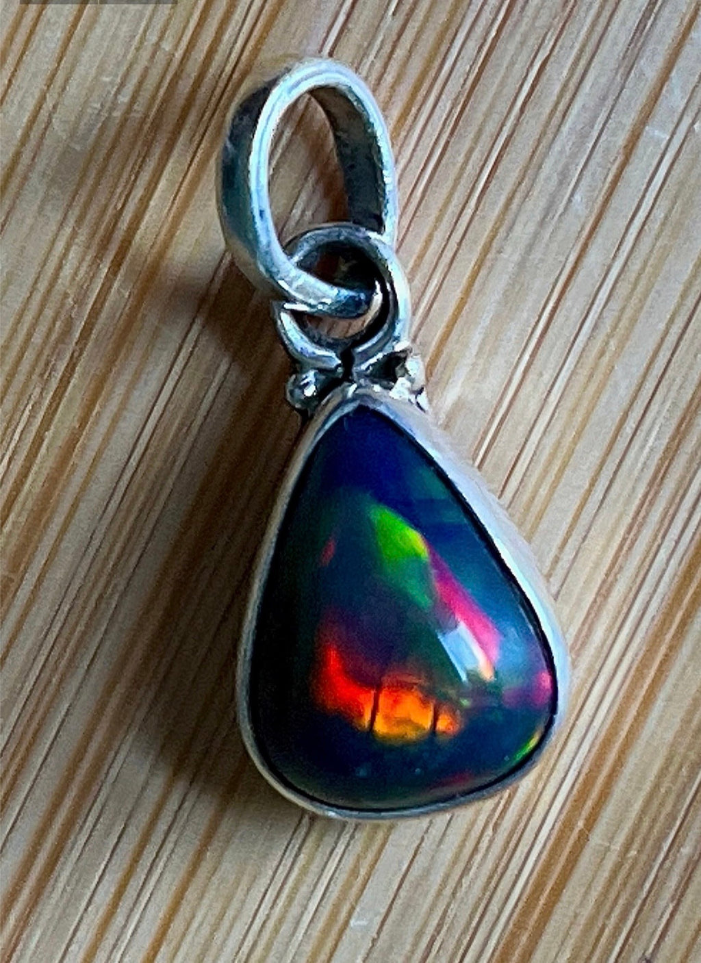 2.99ct Ethiopian opal pendant. AAA grade smoked opal cabochon pear in solid sterling silver. This flashy stone measures 9.6mm x 13mm!