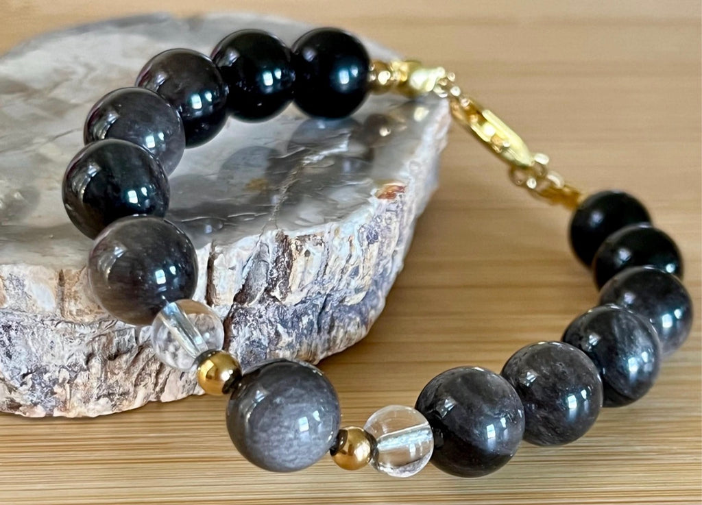 Silver sheen obsidian and clear quartz bracelet and earrings. Pair the “Silver Bells” bracelet and/or earrings with your little black party dress and be the Belle of the Ball!