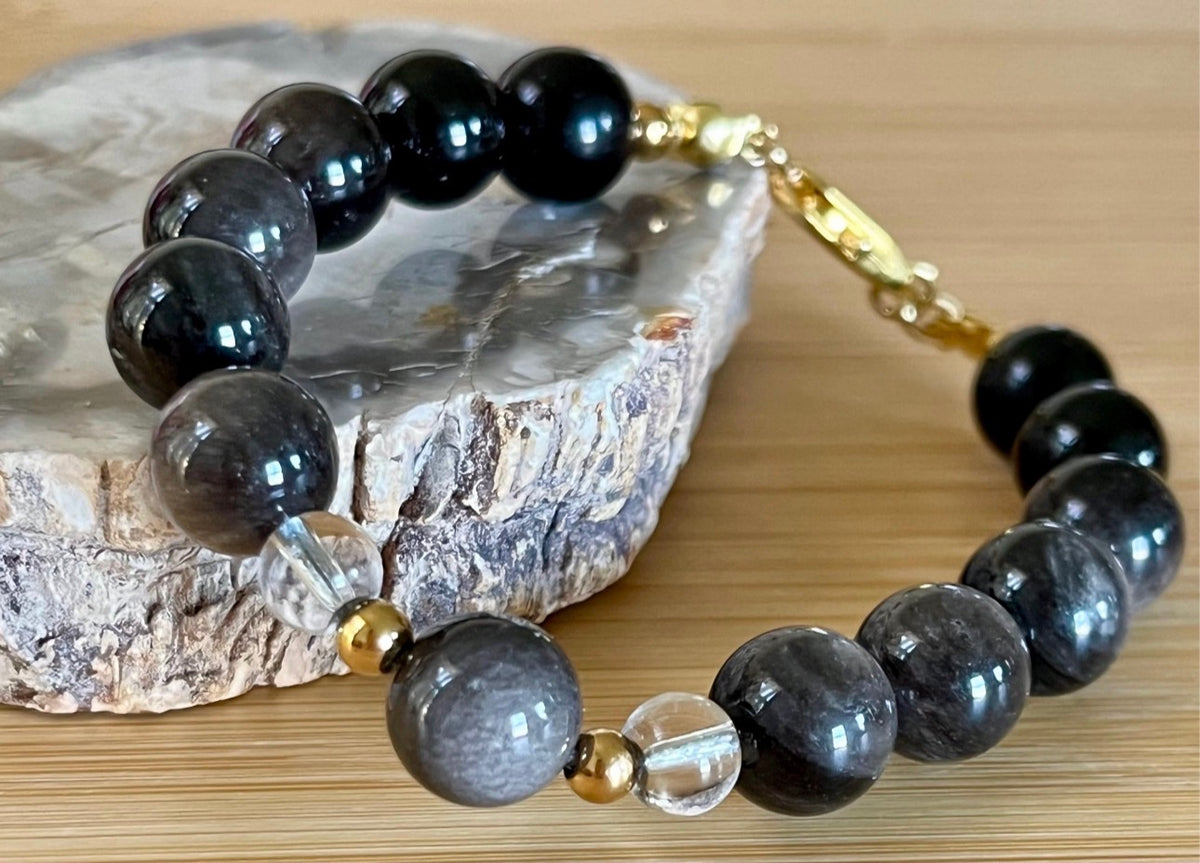 Silver sheen obsidian and clear quartz bracelet and earrings. Pair the “Silver Bells” bracelet and/or earrings with your little black party dress and be the Belle of the Ball!