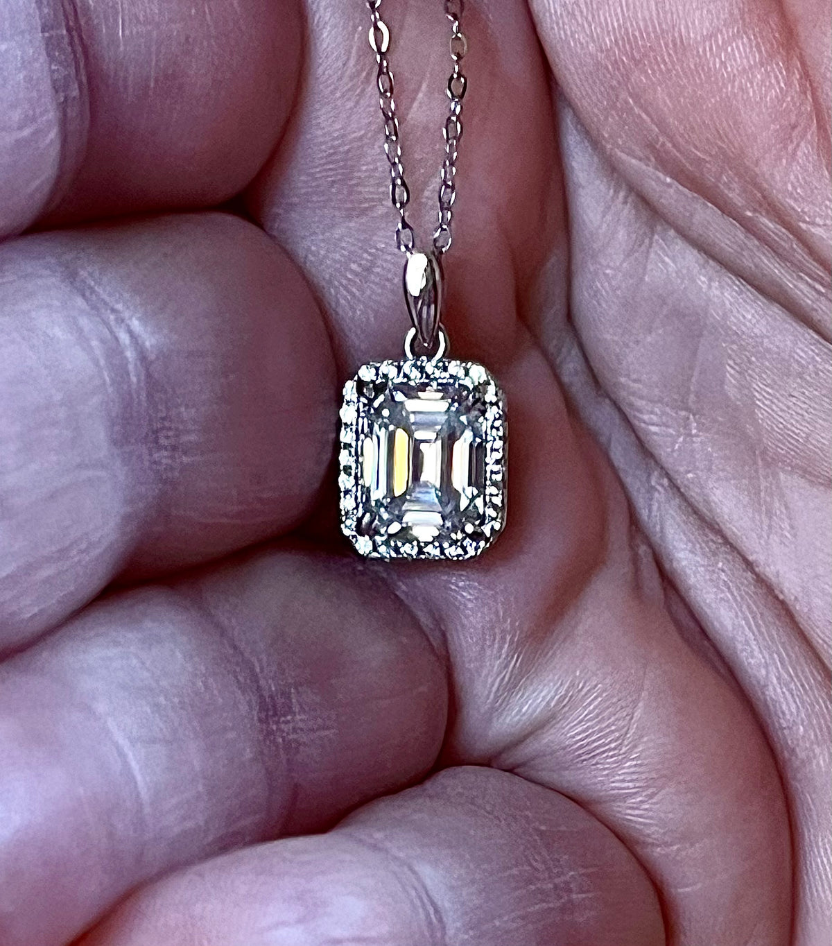 Moissanite necklace. An elegant 3ct certified emerald-cut Moissanite within a halo of shining white zircons, in 18k gold-embraced sterling!
