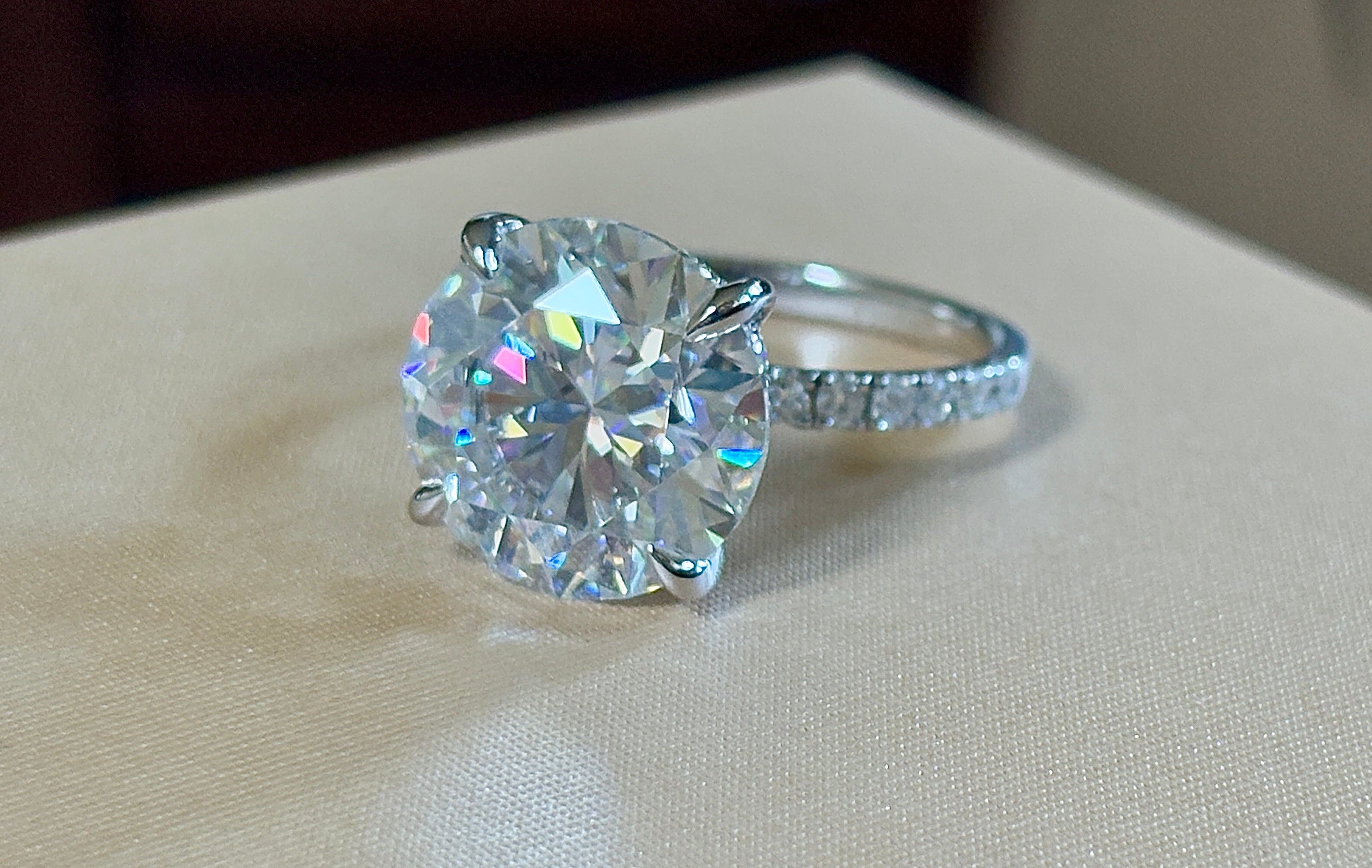 Moissanite solitaire. A glorious 10ct 8H8A Moissanite in a 4-prong mounting with a Moissanite “hidden halo” and shoulders, an 11.3cttw ring!
