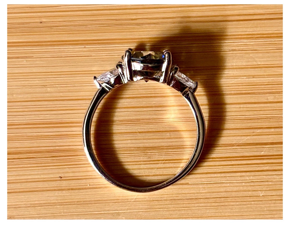 Moissanite ring. A 3ct certified GRAY Moissanite with 1.5cttw of heart-cut white zircons, set in a sterling silver basket 3-stone design!