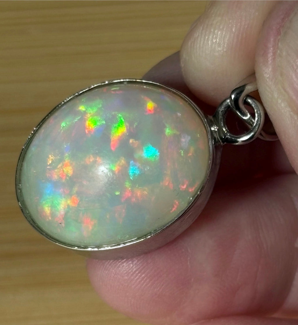 A 17.28ct AAA grade Ethiopian opal pendant with multi-patterned fire and beautiful play of color, hand-picked by Hand Knotted Jewelry!