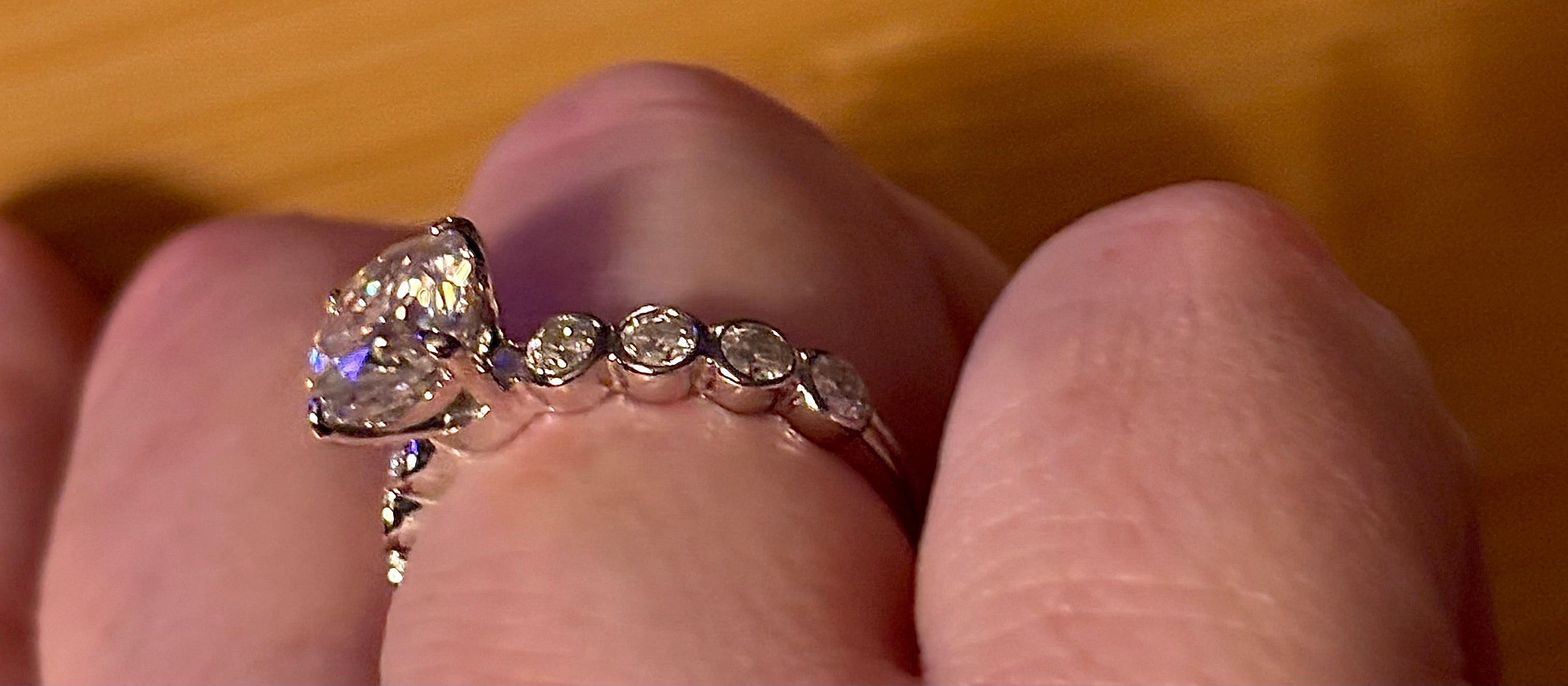 A 3.8cttw designer Moissanite ring with a certified 3ct center stone and 10-point bezel-set stones in sterling silver and 18k gold!
