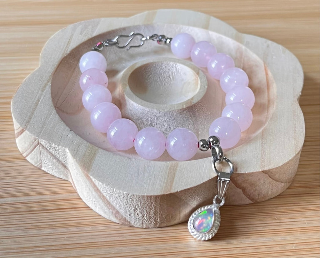 Madagascar rose quartz bracelet. 10mm beads with stainless steel components. The featured sterling silver pendants are sold separately.