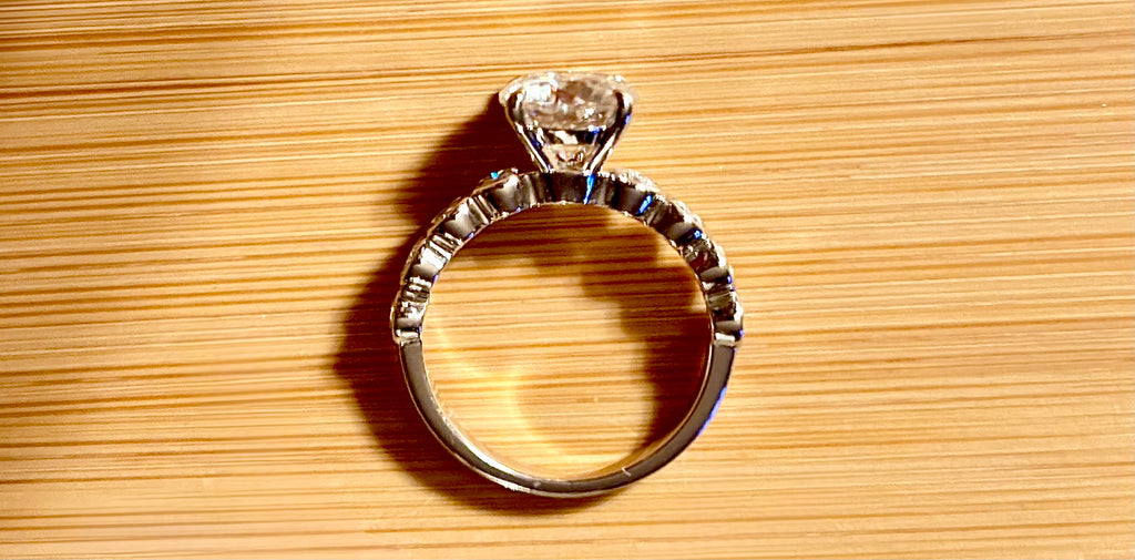A 3.8cttw designer Moissanite ring with a certified 3ct center stone and 10-point bezel-set stones in sterling silver and 18k gold!