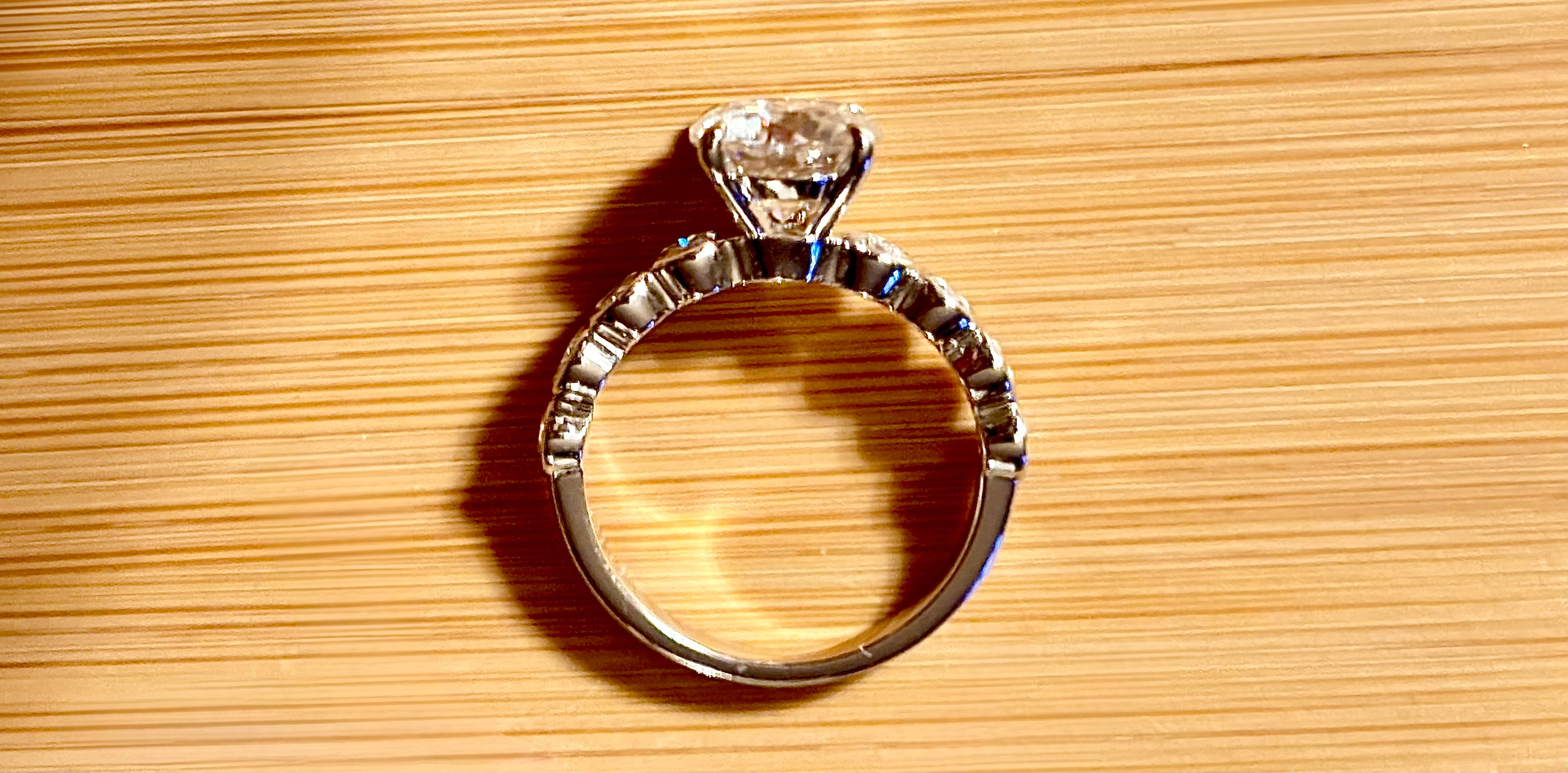 A 3.8cttw designer Moissanite ring with a certified 3ct center stone and 10-point bezel-set stones in sterling silver and 18k gold!