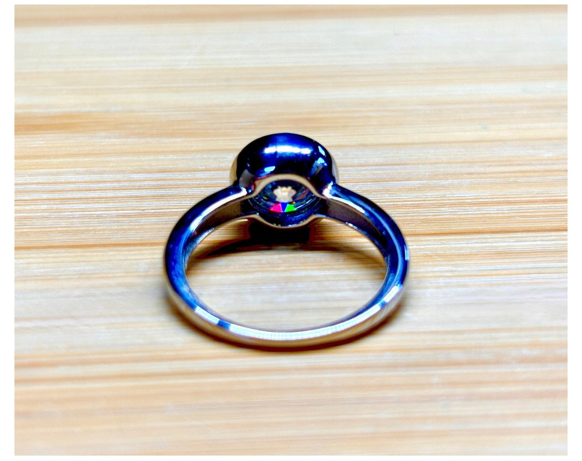 Moissanite solitaire. A 3ct certified round brilliant Moissanite in a weighty solid sterling silver bezel mounting with Seiko-electroplated 18k! A sleek, minimalist design!
