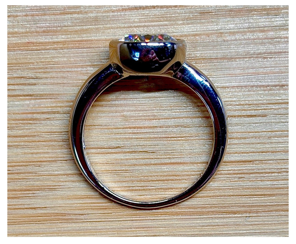 Moissanite solitaire. A 3ct certified round brilliant Moissanite in a weighty solid sterling silver bezel mounting with Seiko-electroplated 18k! A sleek, minimalist design!