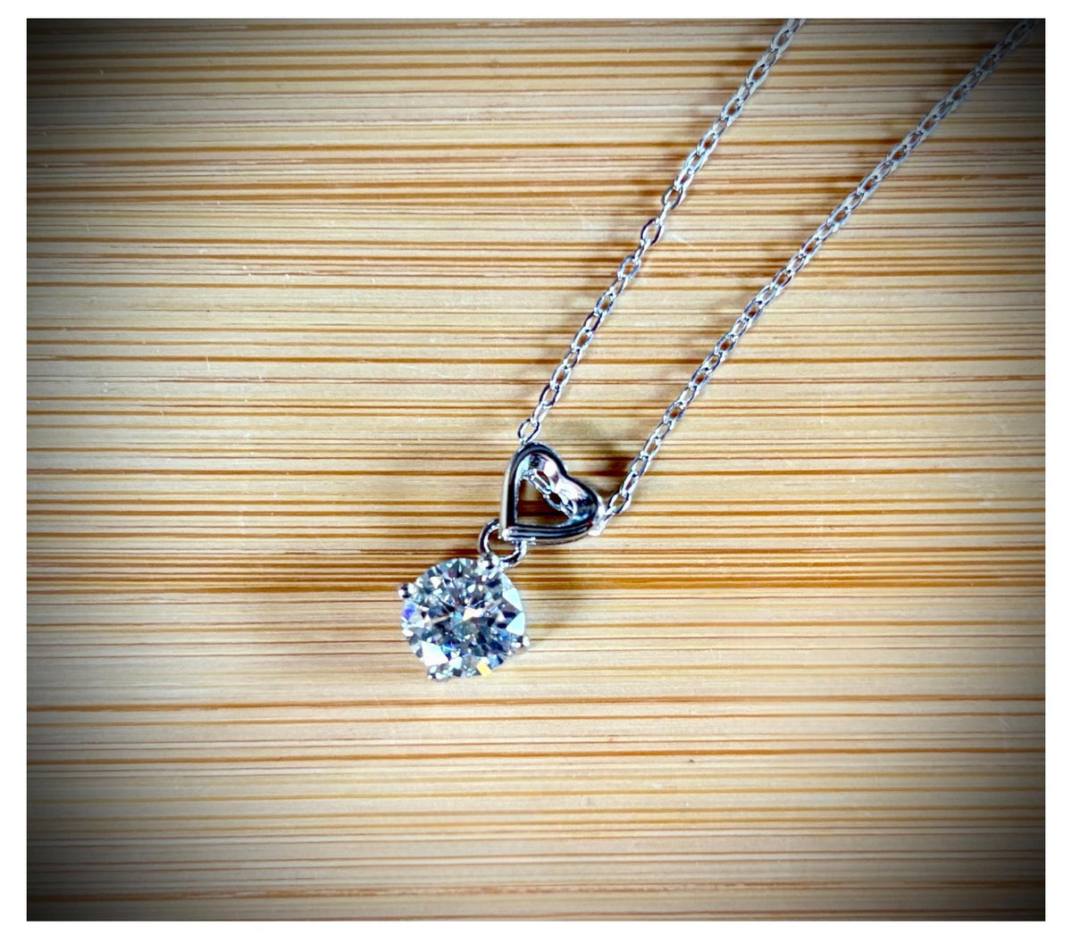 Moissanite necklace. A romantic heart-shaped pendant featuring a certified 1ct round WHITE or BLUE round brilliant Moissanite in sterling silver!