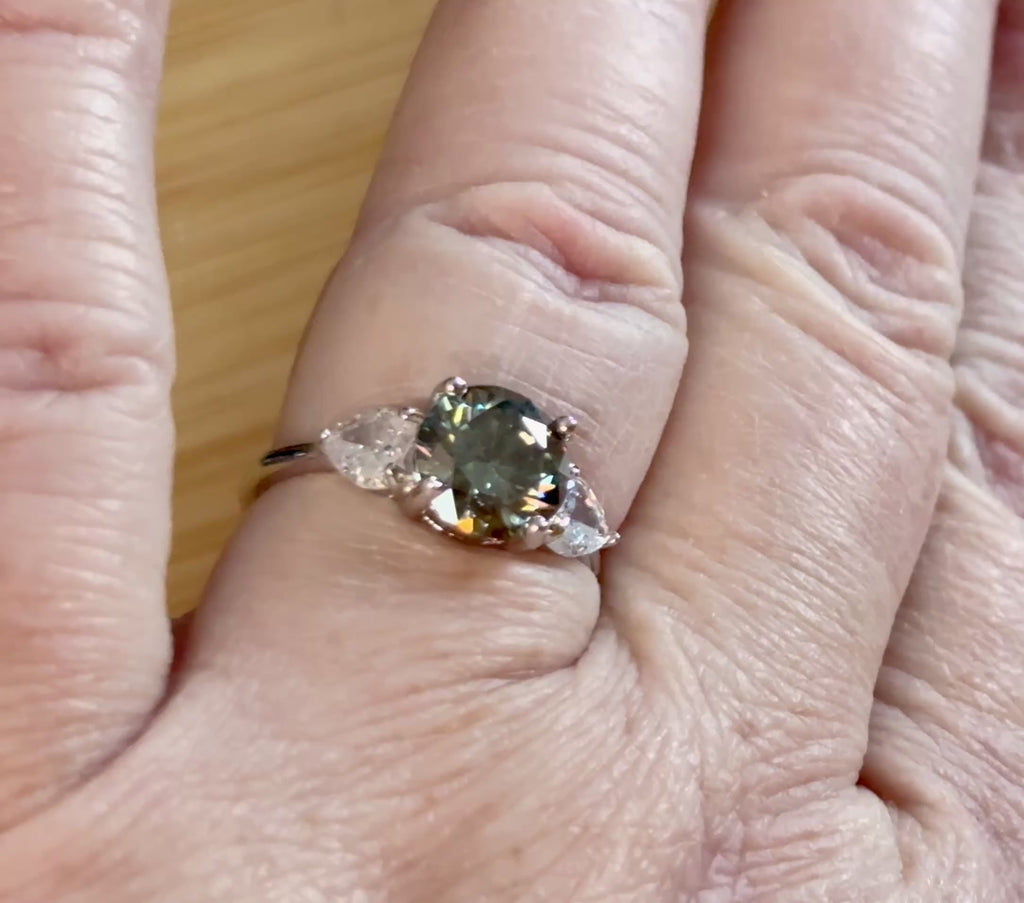 Moissanite ring. A 3ct certified GRAY Moissanite with 1.5cttw of heart-cut white zircons, set in a sterling silver basket 3-stone design!