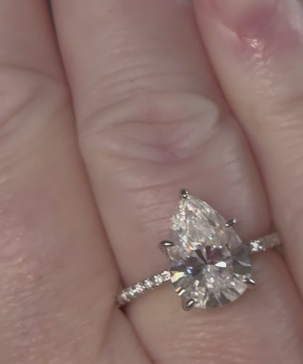 A certified 5ct pear-cut Moissanite solitaire in 925 sterling OR 935 Argentium silver with 18k, with pavé-set Moissanite shoulders and Moissanite hidden halo!