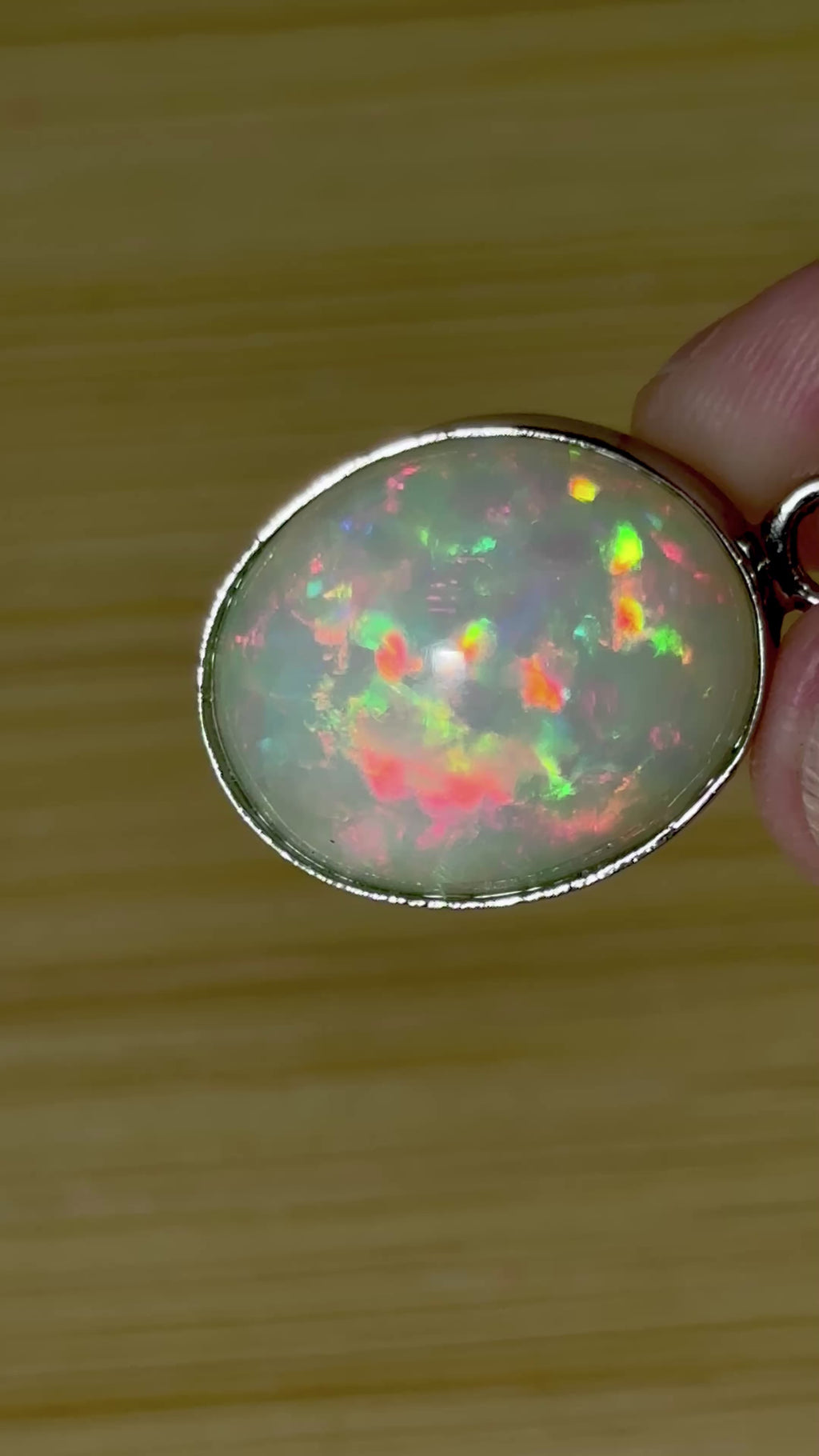 A 17.28ct AAA grade Ethiopian opal pendant with multi-patterned fire and beautiful play of color, hand-picked by Hand Knotted Jewelry!
